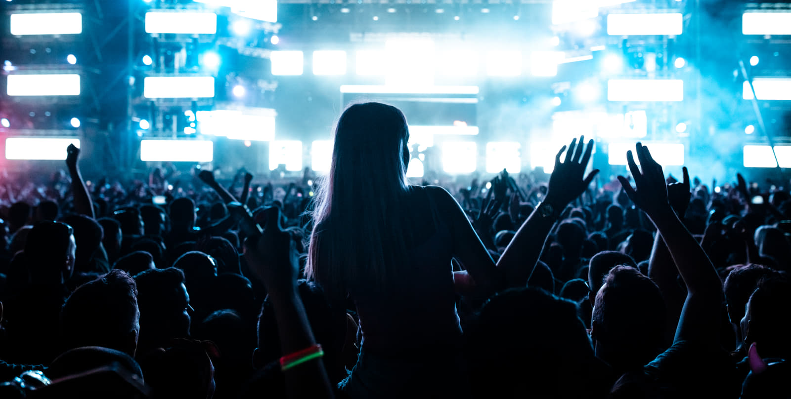 rear-view-carefree-fans-having-fun-music-festival-front-illuminated-stage-night